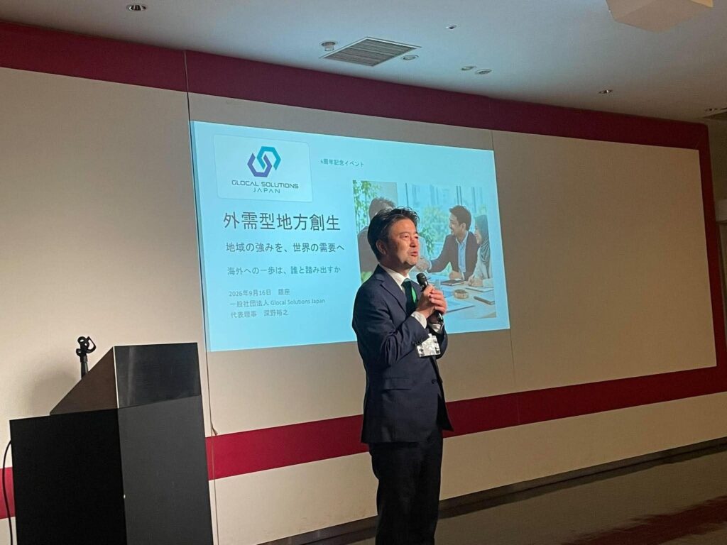 在标题幻灯片前发言的深野裕之代表理事